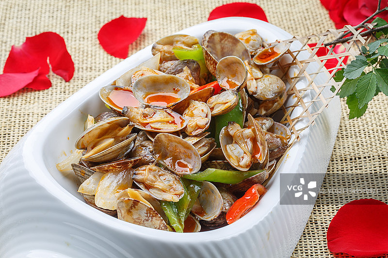 异形白瓷盘装的海鲜辣炒花蛤图片素材