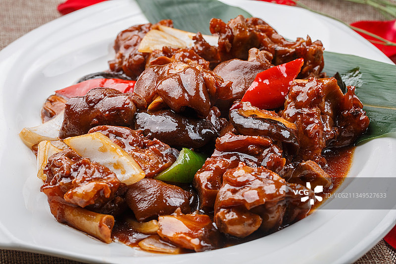 白色圆形瓷盘装的红烧香菇炖猪手（猪蹄）图片素材
