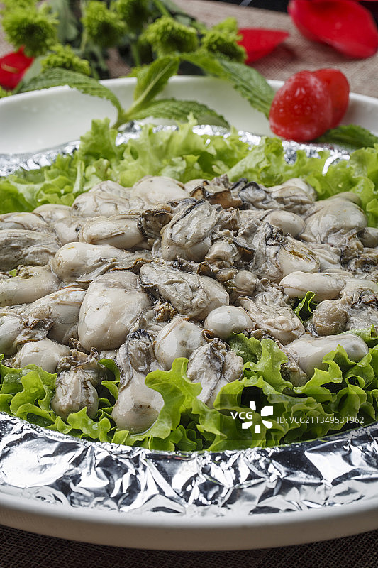 白色瓷盘装的白灼生蚝青口贝图片素材