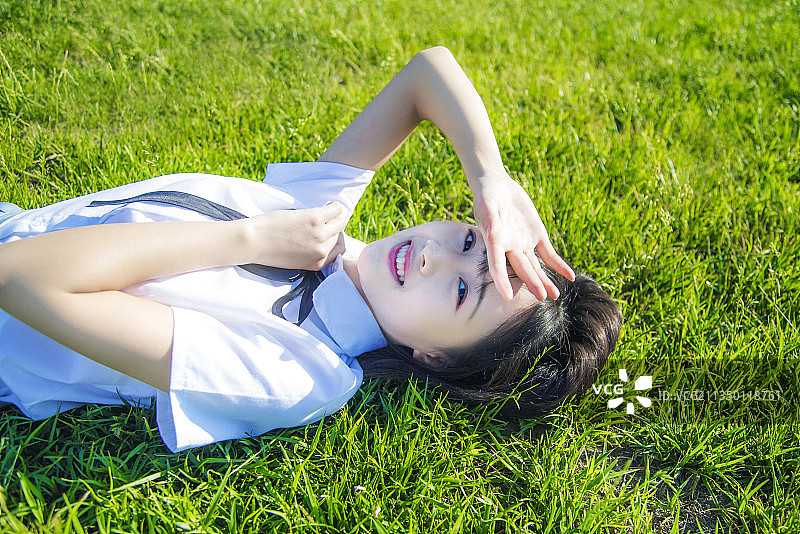 室外穿着JK制服躺在草地上的女孩图片素材