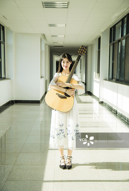 走廊里抱着吉他的女孩图片素材