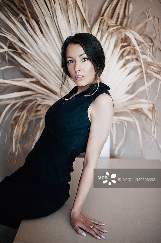 靠墙站立的美丽年轻女人 портрет图片素材