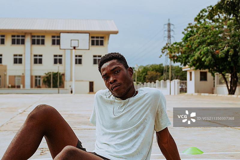 坐在 retaining wall 上的年轻男子肖像，阿克拉，加纳图片素材