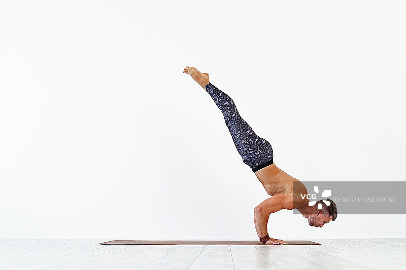 年轻男子在白色背景下做瑜伽图片素材