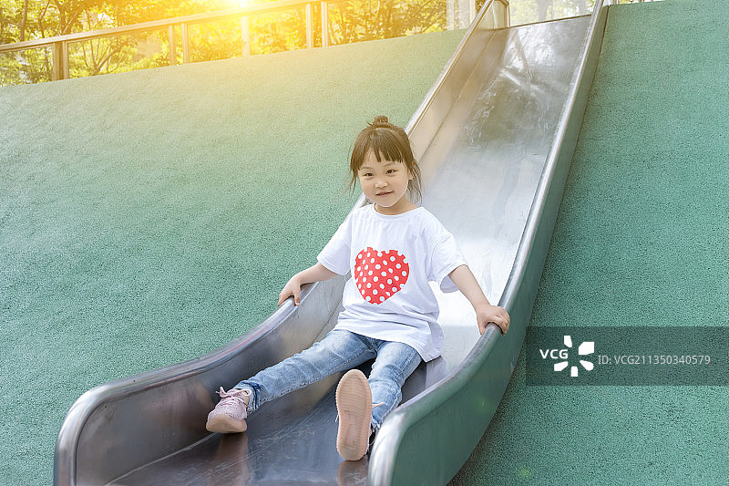 游乐场玩滑梯的小女孩图片素材