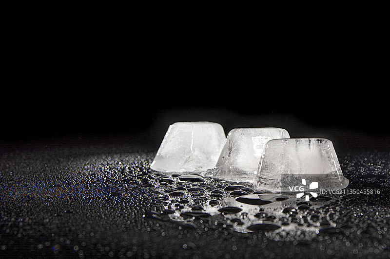 黑色背景下桌子上的冰块特写图片素材