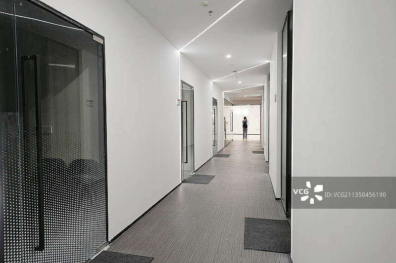 办公室走廊，远处人经过图片素材