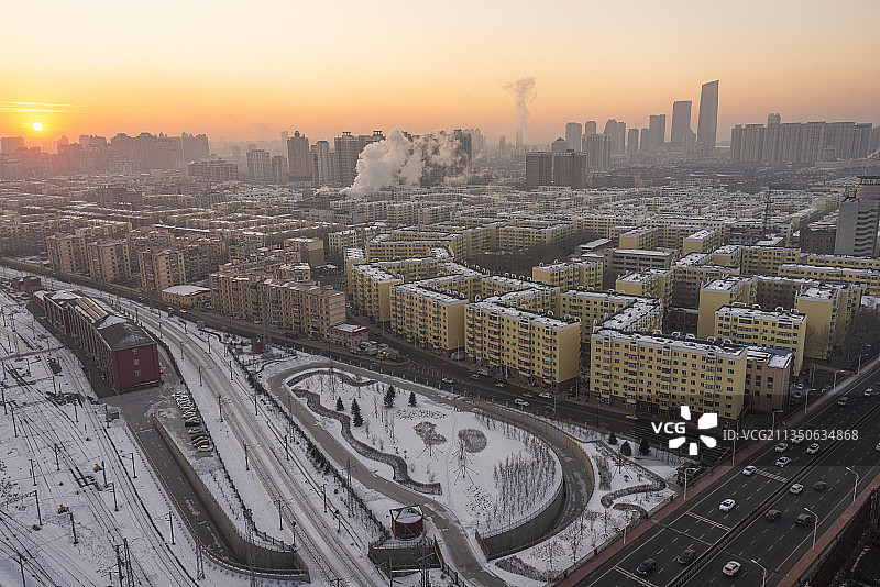 冬日哈尔滨，夕阳下的老旧小区和远处的高楼大厦图片素材