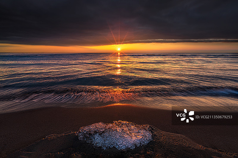 初春的安大略湖畔，被浪冲上岸的冰渣和朝阳形成强烈的冷暖对比。图片素材