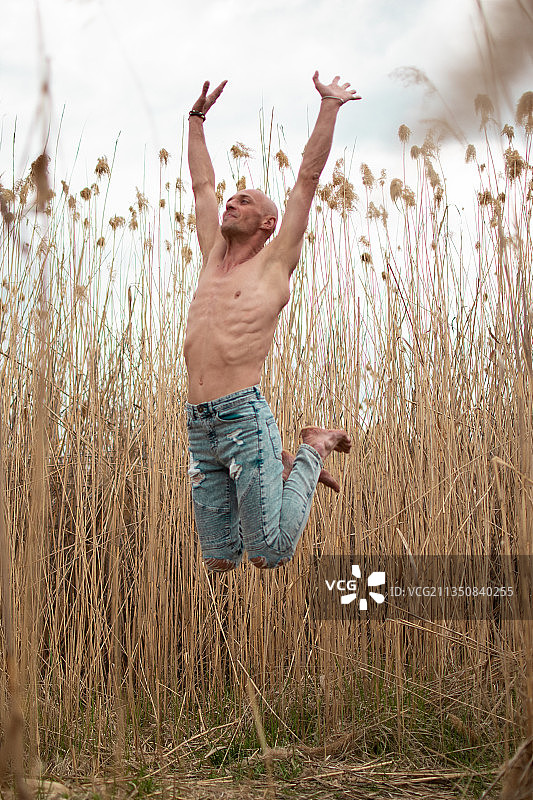 在乌克兰哈尔科夫的田野上跳跃的无上衣男子图片素材