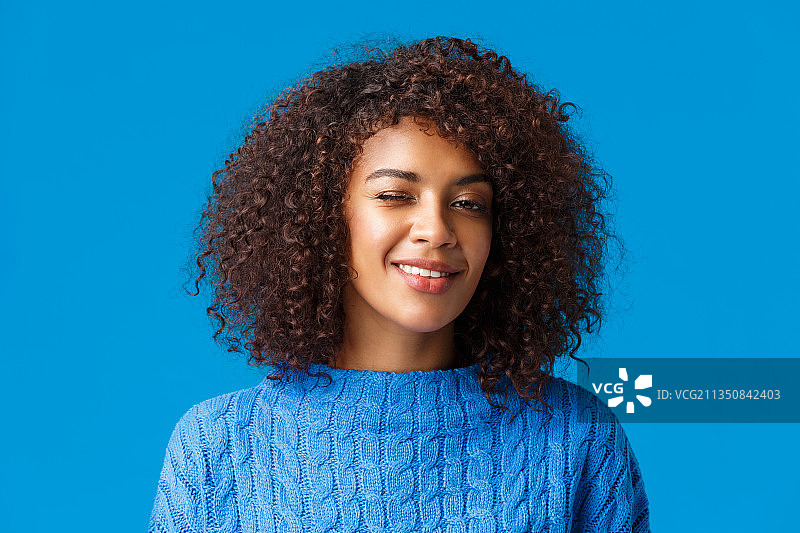 蓝色背景下的微笑的年轻女子肖像图片素材