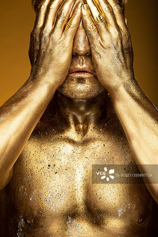 乌克兰金色无上衣男人用手遮脸的特写图片素材