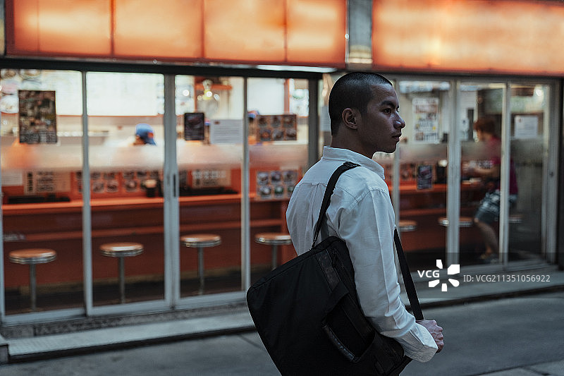 光头党在晚上路过日本餐厅。图片素材