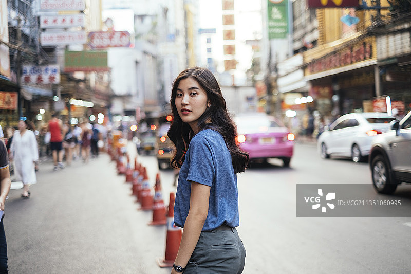 美丽的亚洲泰国女人的肖像穿着蓝色衬衫在中国城。曼谷。图片素材