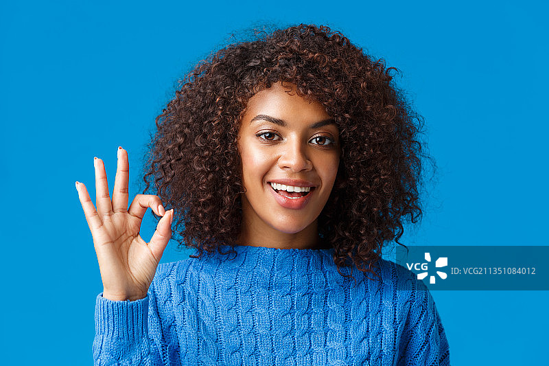 蓝色背景下的微笑的年轻女子肖像图片素材