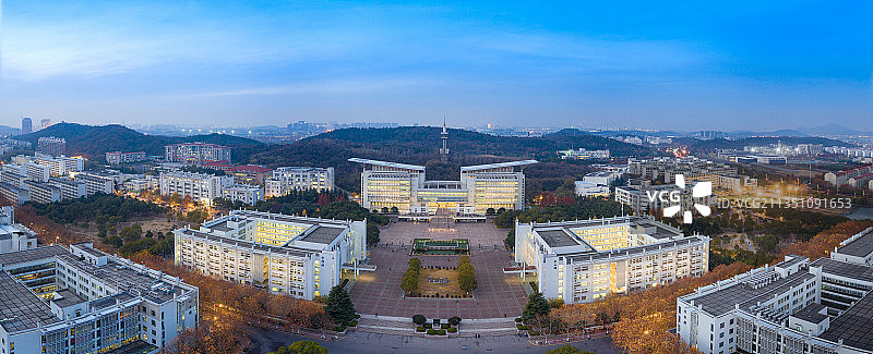 蓝色天空下远处有山丘的灯光璀璨的白色现代建筑群落的大学校园图片素材