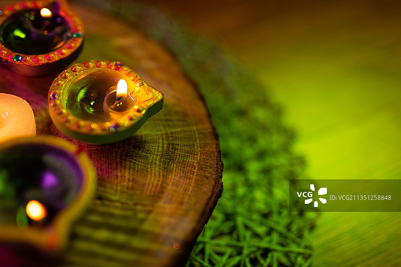 小型装饰陶罐中的点燃的蜡烛和圆形木板上燃烧的茶蜡图片素材