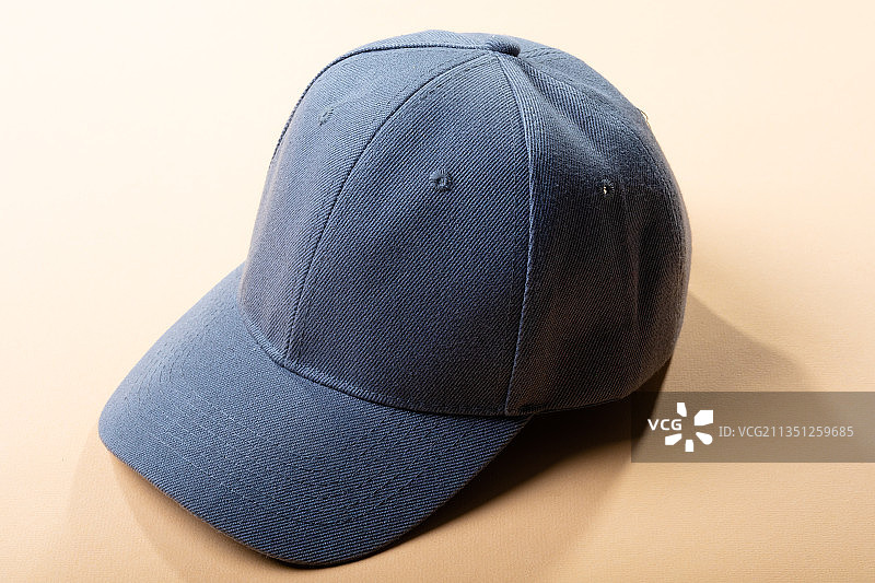 浅棕色背景上的传统灰色棒球帽构图图片素材