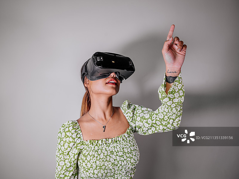 在家中通过虚拟现实设备观看增强现实的亚洲女性图片素材