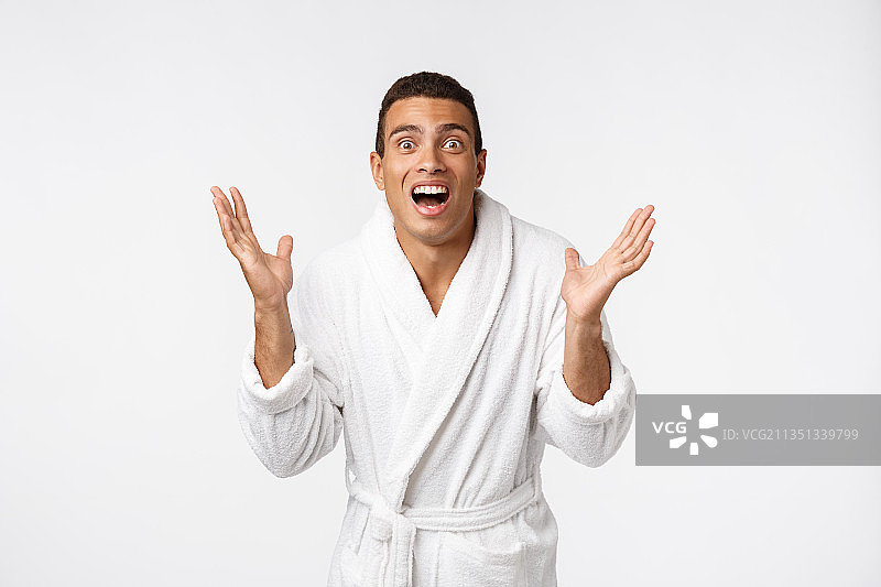 年轻男人穿浴袍站在白色背景前的肖像图片素材