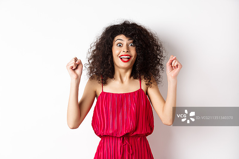 身穿红色连衣裙，站在白色背景前的微笑女人像图片素材