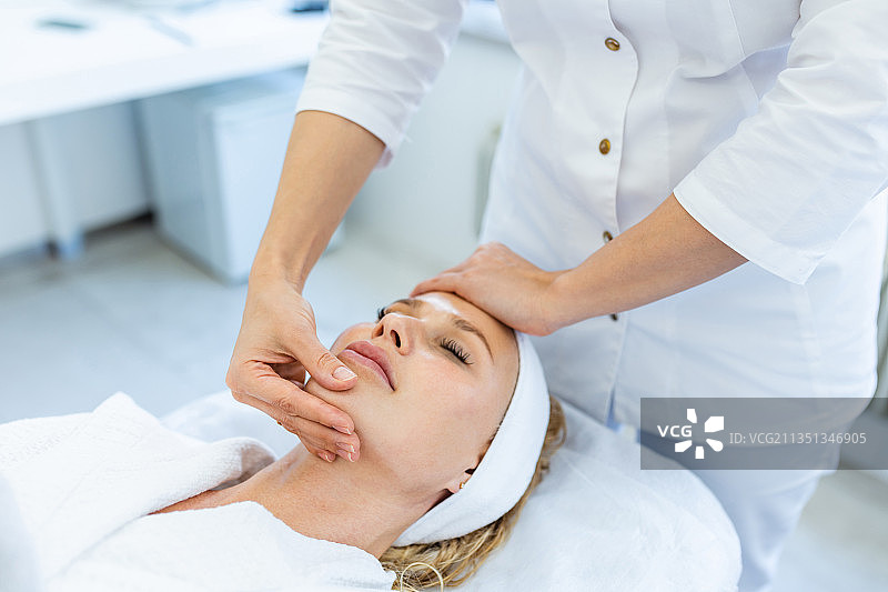 女子在水疗中心为顾客按摩图片素材