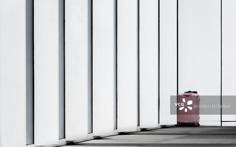 美术馆幕墙边的粉色行李箱图片素材