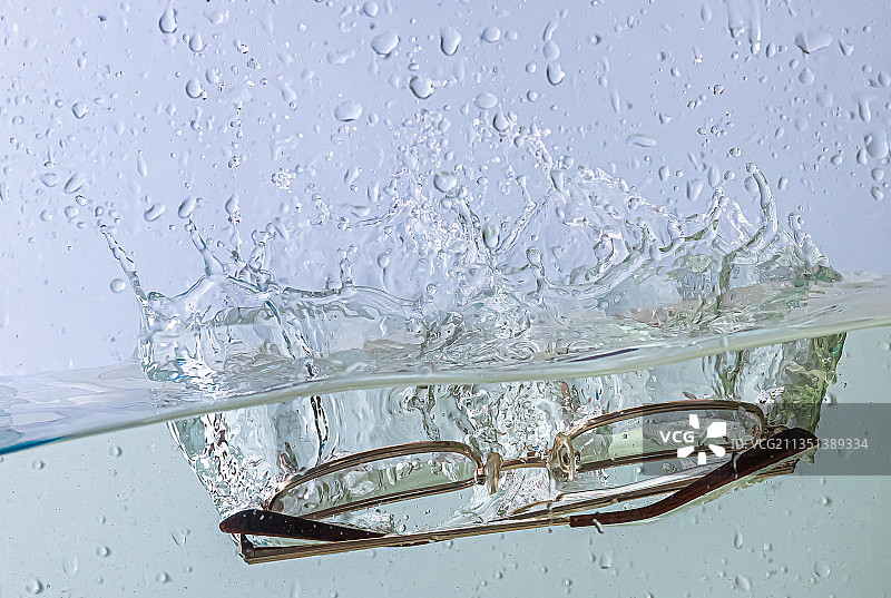 眼镜落入水中，水花四溅，气泡飞舞图片素材