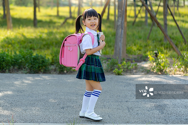 背着书包边走边看书的小学生图片素材