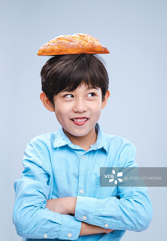 面包放在头顶的小男孩图片素材