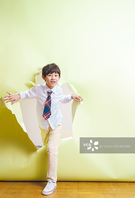 小男孩跨过破碎的背景纸图片素材