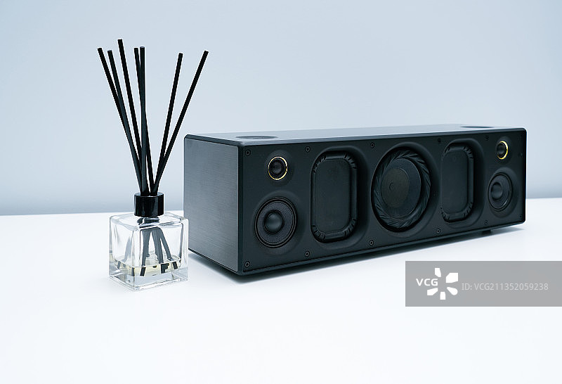 蓝牙音响和香薰瓶放在白色桌面上图片素材