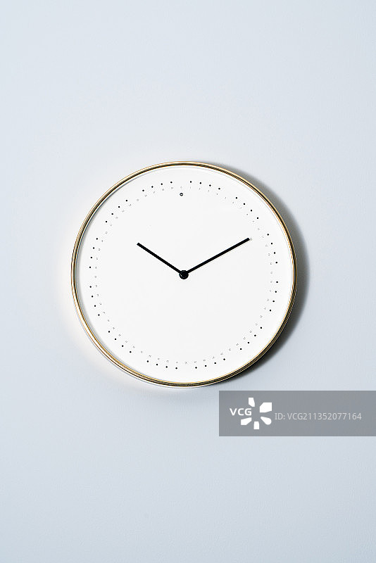 一个时钟挂在淡蓝色墙壁上图片素材