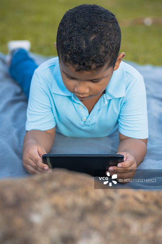 男孩在巴拿马的家中躺在床上使用平板电脑图片素材