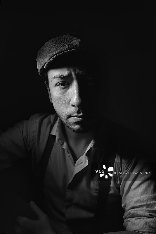 坐在黑色背景前的青年肖像，意大利罗马图片素材