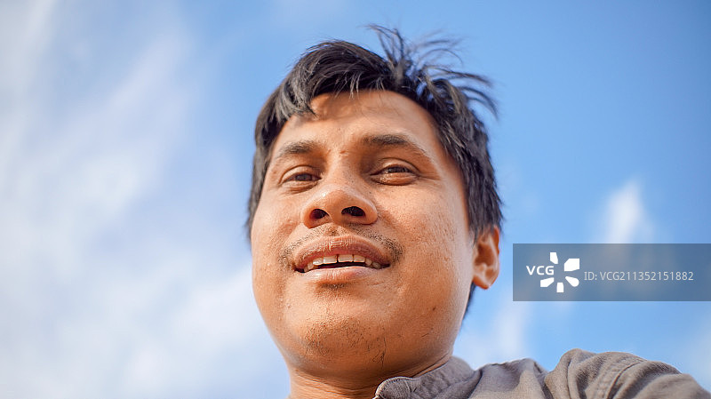 印度尼西亚，Batipuh，天空背景下的年轻男子肖像图片素材