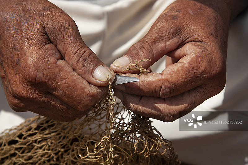男人拿着渔网的中段镜头，委内瑞拉苏克雷图片素材