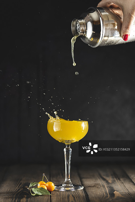 桌上玻璃杯中倾倒的饮品特写图片素材