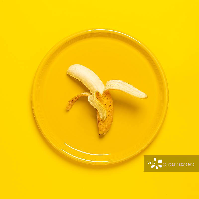 黄色背景下盘子里的芒果高角度视图，美国堪萨斯州小鹿溪镇图片素材