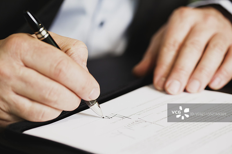 男子在纸上书写的腰部特写图片素材