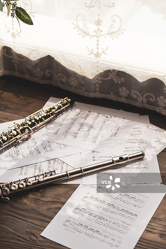窗帘旁的木地板上的单簧管和长笛图片素材