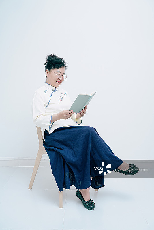 穿着传统中式服装的中年妇女在读书图片素材