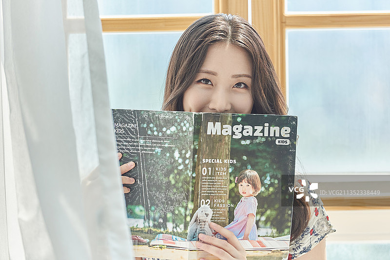 阅读杂志的微笑女人图片素材