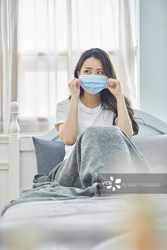 生病的女人戴着口罩隔离图片素材