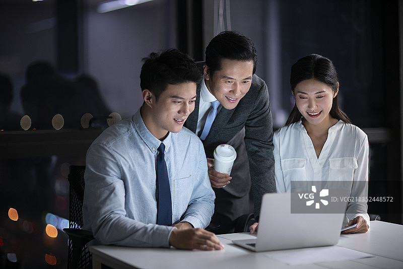 商务人士晚上在办公司加班讨论工作图片素材