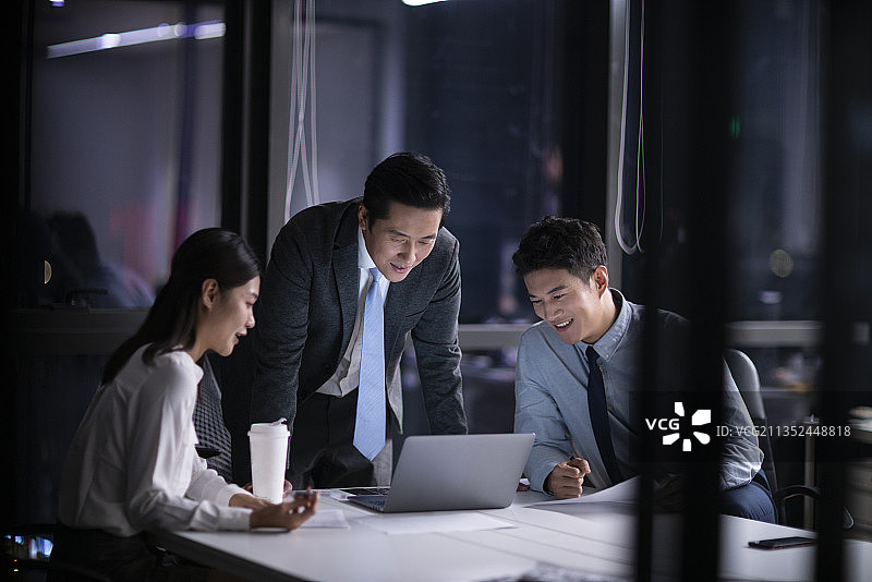 商务人士晚上在办公司加班讨论工作图片素材