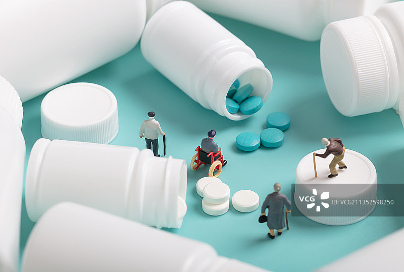 微缩创意白色药瓶散落的药物和中老年人群图片素材