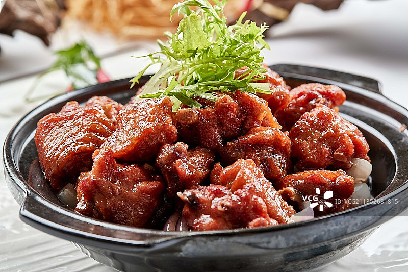 黑色砂锅装的葱香红烧鸡块图片素材