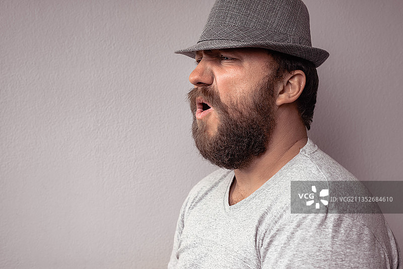 男人戴帽子靠墙的特写镜头图片素材