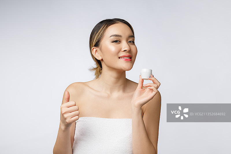 年轻女子在白色背景下化妆的特写图片素材